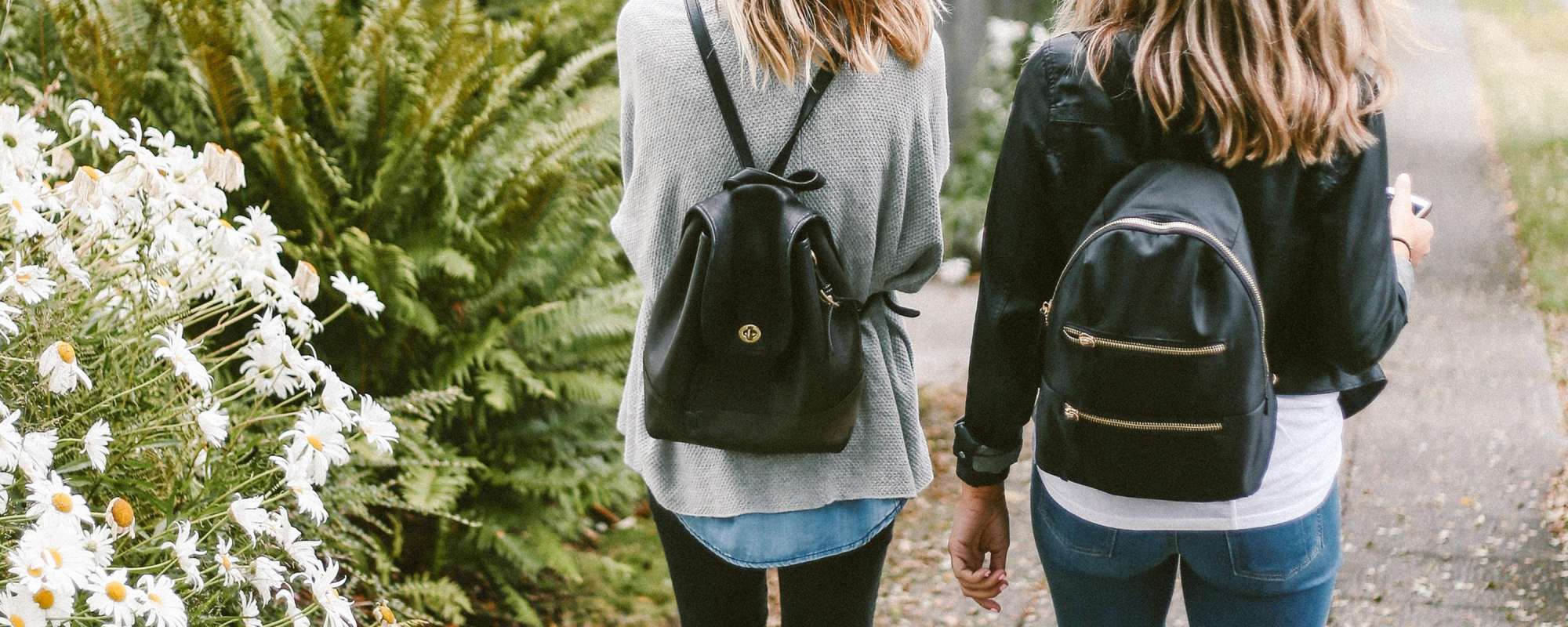 Image of two girls walking down a path on their mobile phones - Libresse